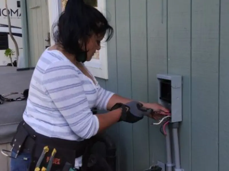 Licensed electrician wiring an exterior subpanel in Genoa